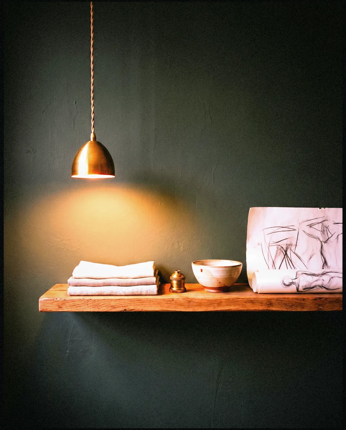 A pinboard of fabric swatches under a warm brass pendant