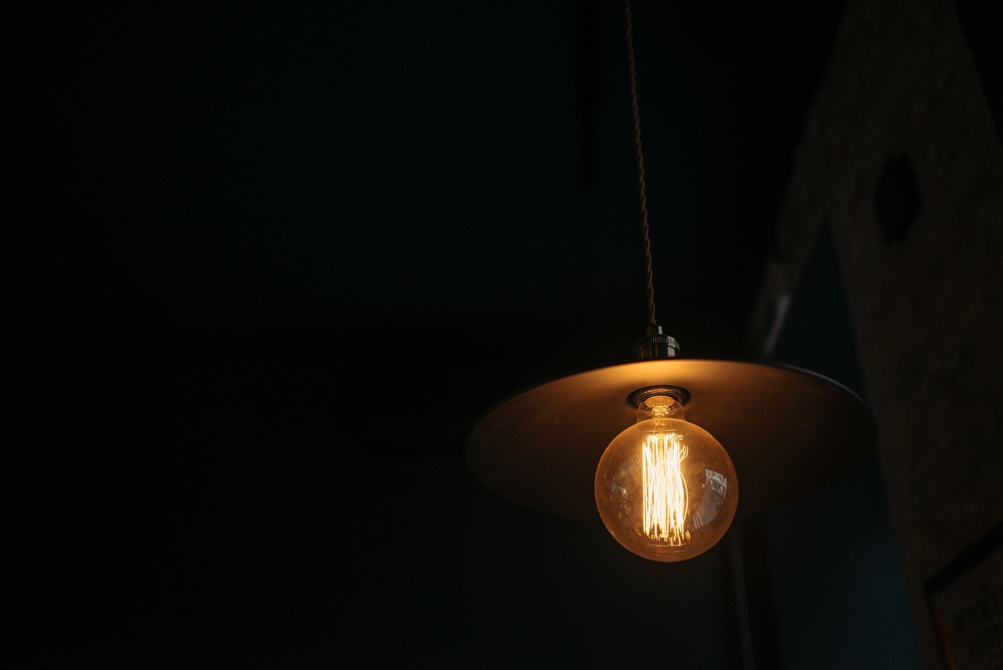 A warm filament pendant glowing against the dark