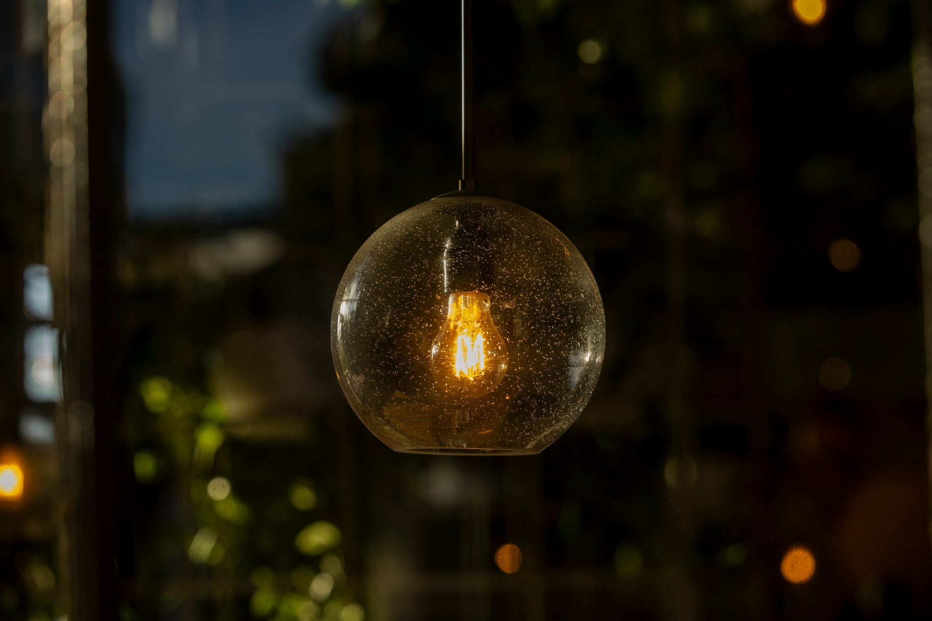A quiet studio mood at dusk, a brass lamp on, a warm pool of light