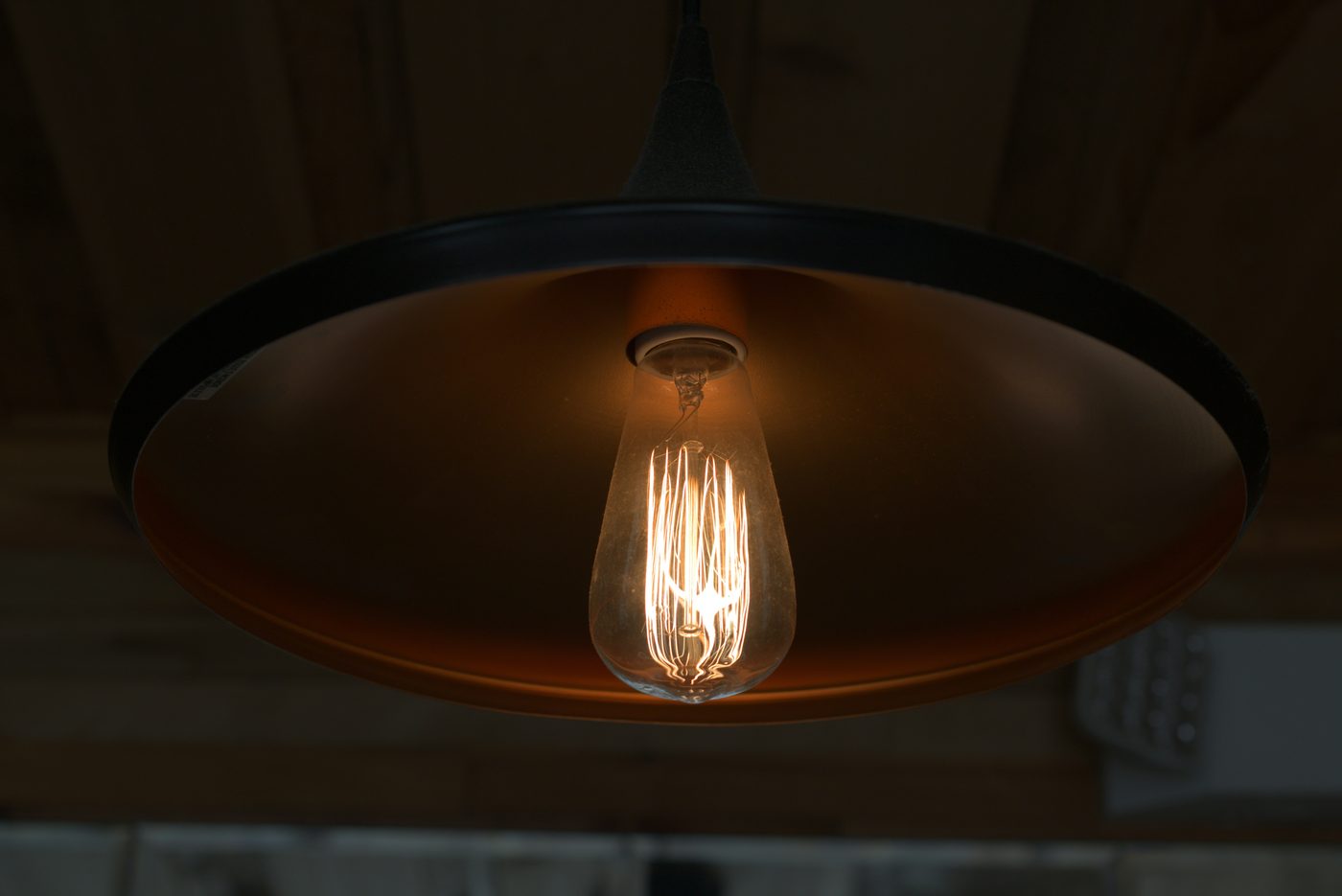 A warm 2700K filament bulb glowing in a pendant