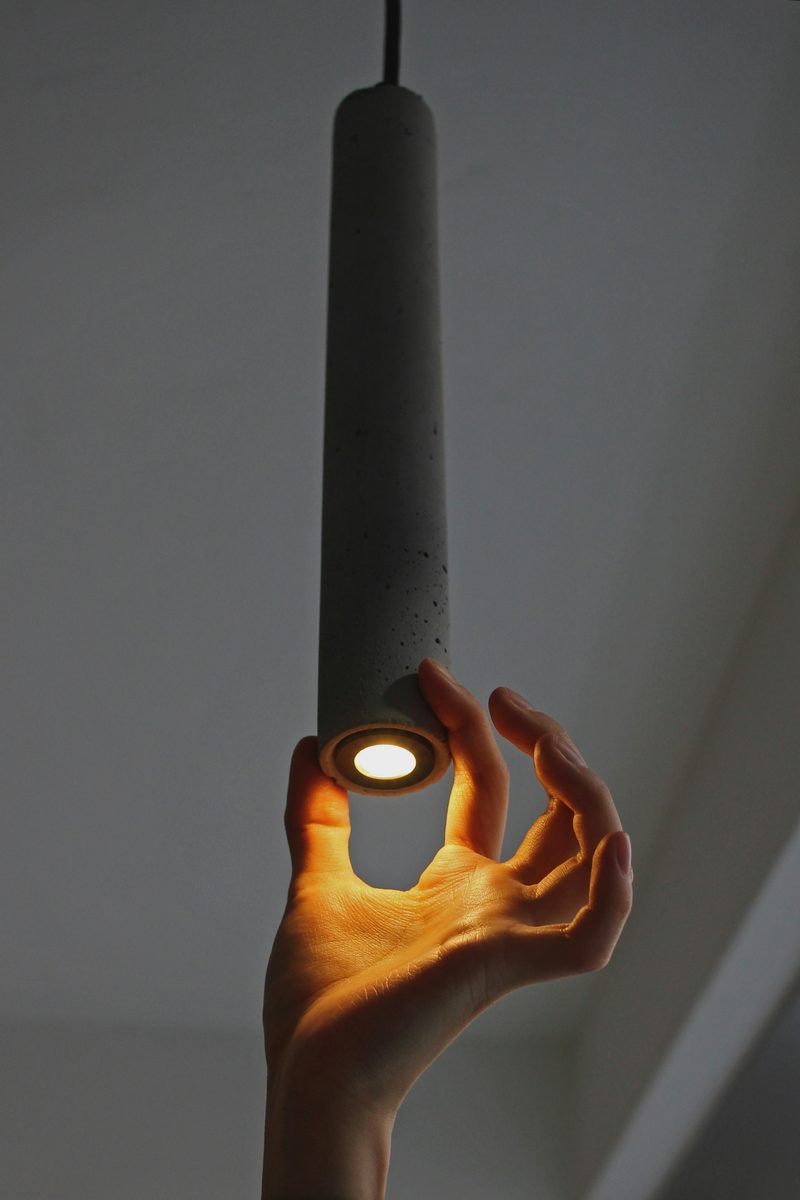 A warm pendant held in the hand, the glow up close