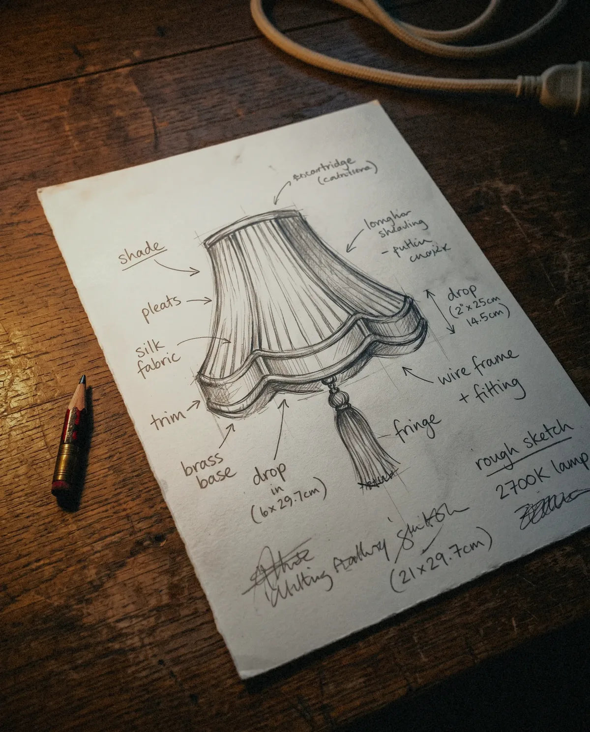 A pencil sketch of a lamp shade on a worn oak desk
